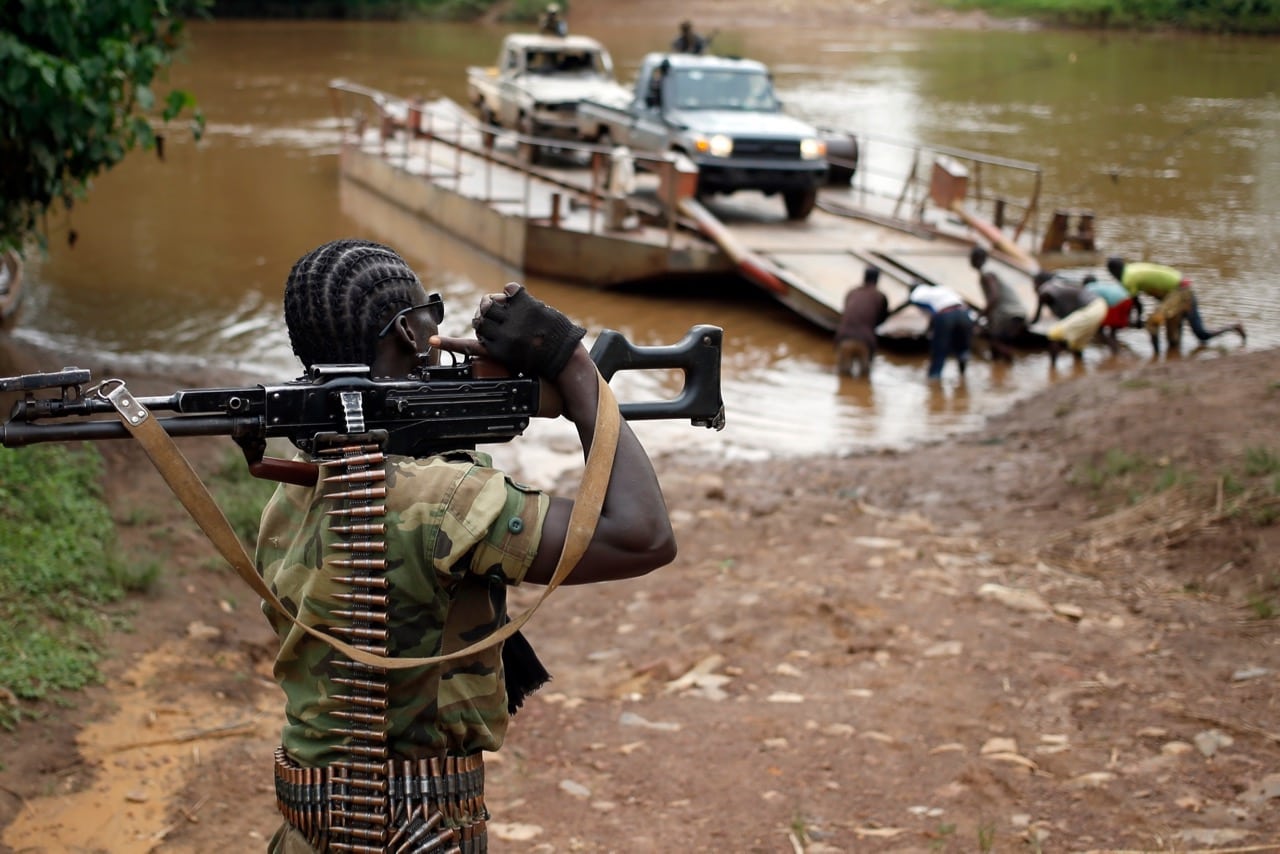 In this 9 June 2014 photo, a member of the now disbanded Seleka rebels holds his machine gun as other fighters cross a river near the town of Kuango, Central African Republic, close to the border with Democratic Republic of Congo, REUTERS/Goran Tomasevic