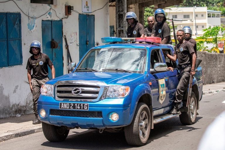 Comoros Gendarmerie officers stand on the back of a car as they disperse opposition supporters, in Moroni, 25 March 2019, GIANLUIGI GUERCIA/AFP/Getty Images