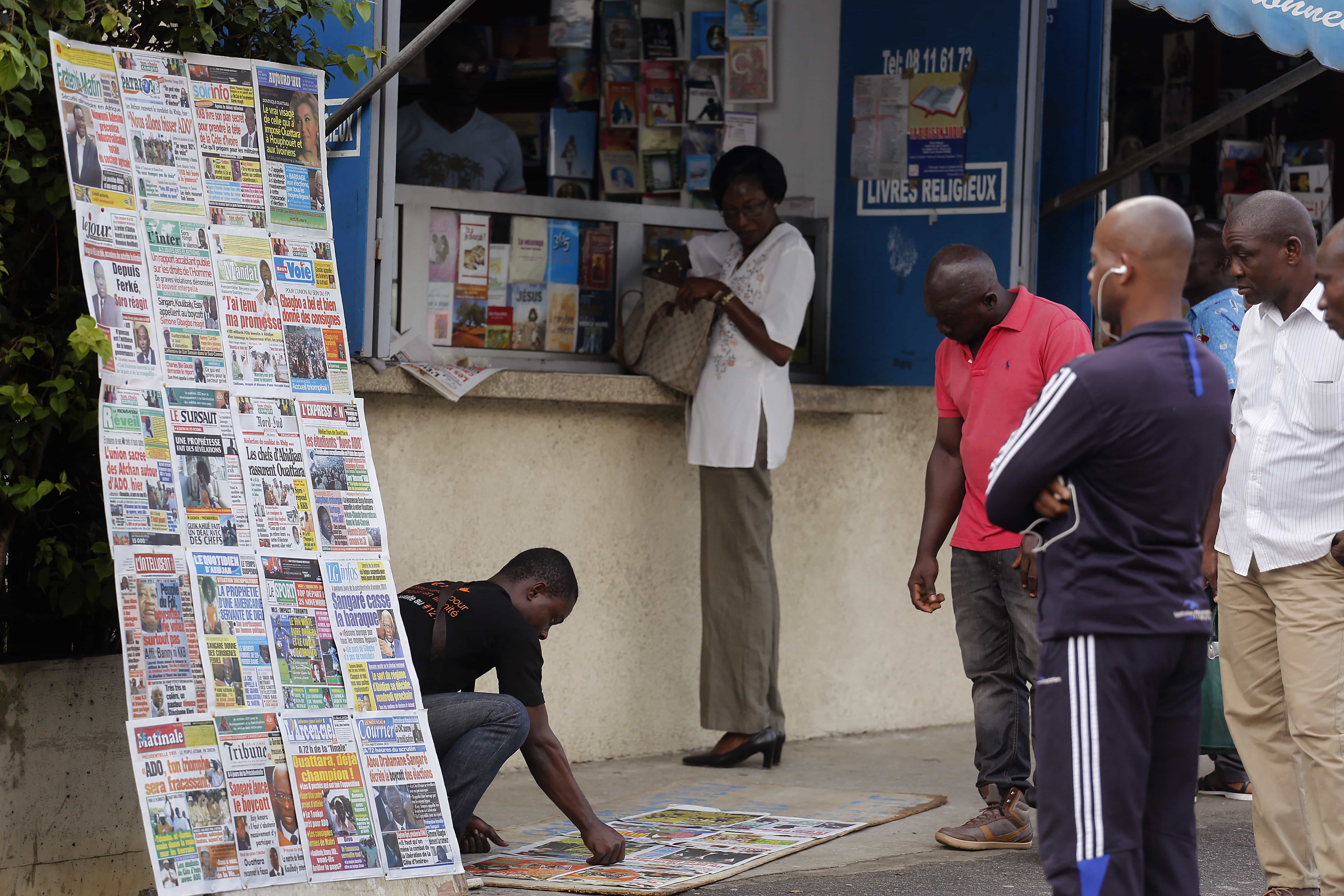 People read local newspapers commenting on the elections in Abidjan, Cote d'Ivoire, 22 October 2015, AP Photo/Schalk van Zuydam