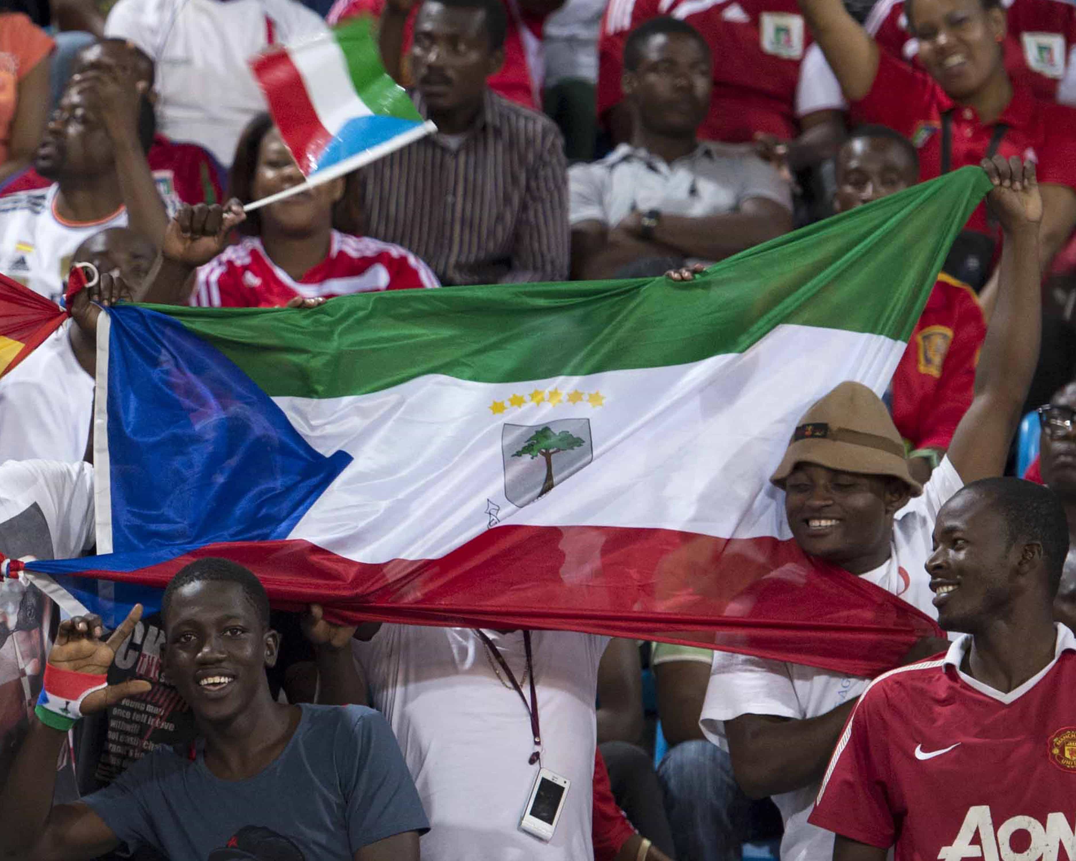 Supporters hold national flags of Equatorial Guinea before a soccer match with Spain, in Malabo, Equatorial Guinea, 16 November 2013., AP Photo/Diario AS, Juan Flor, FILE