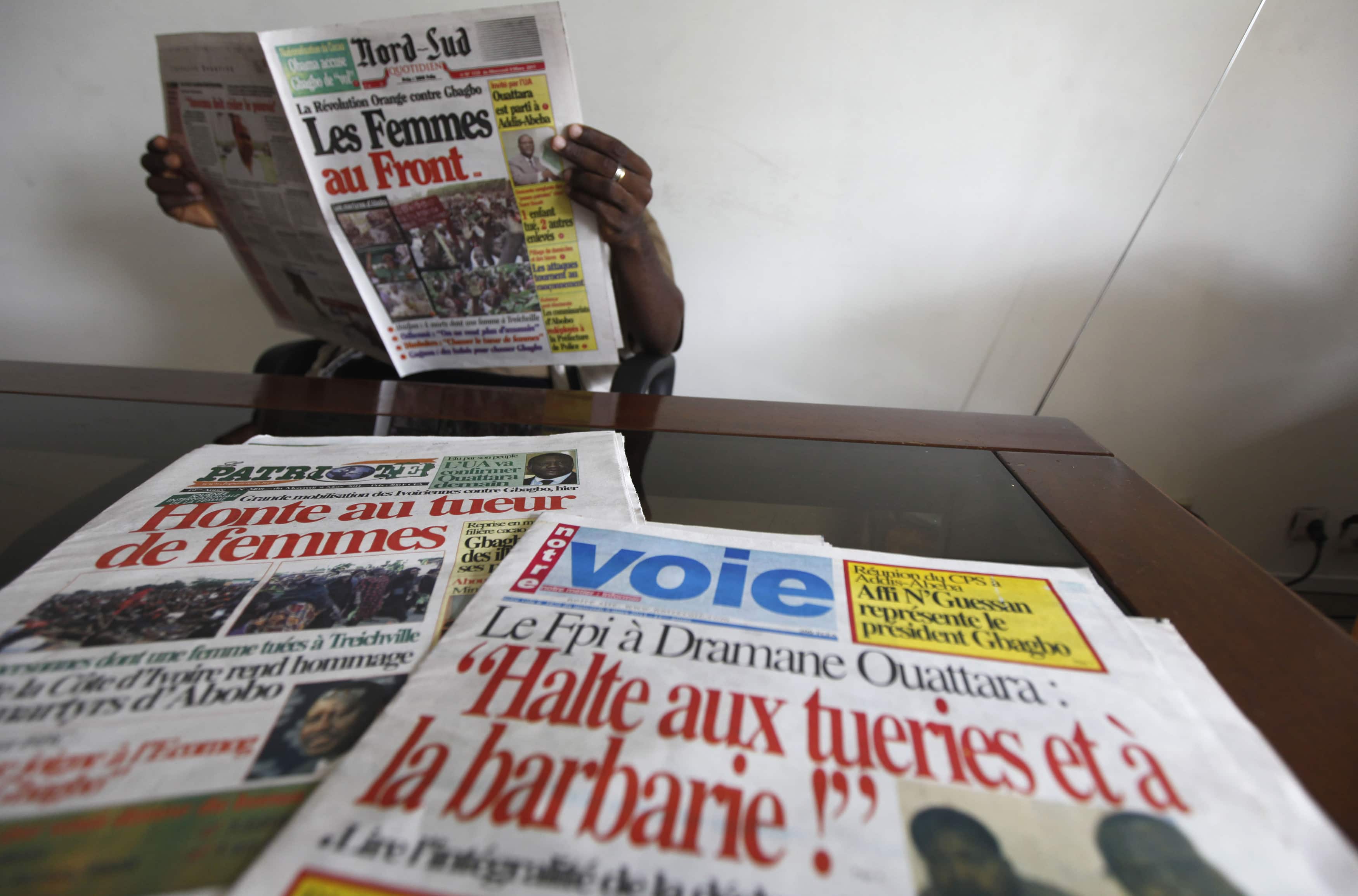 A man reads newspapers in Abidjan, 14 March 2011. , Thierry Gouegnon/Reuters