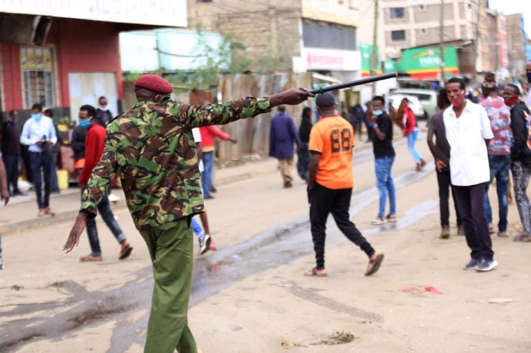 A police officer disperses residents in Eastleigh, Nairobi, Kenya, as they protest restrictions on their movements due to Covid-19, 11 May 2020, Billy Mutai/SOPA Images/LightRocket via Getty Images