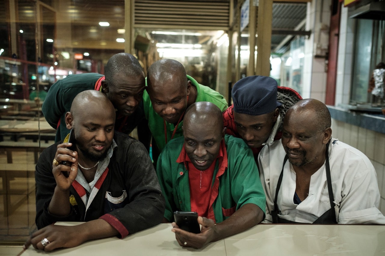 Employees at a food court watch a presidential campaign video on a smartphone in Nairobi, Kenya, 5 September 2017, YASUYOSHI CHIBA/AFP/Getty Images
