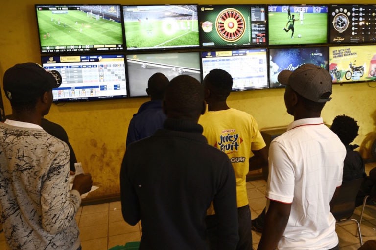 Sports enthusiasts follow various games on screens at a sports betting shop, Nairobi, Kenya, 15 July 2019, SIMON MAINA/AFP via Getty Images