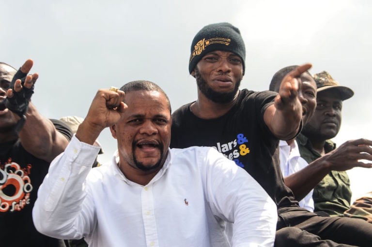 Radio show host Henry Costa (C), a US resident and prominent critic of the president, gestures to supporters after landing in Monrovia, Liberia, 19 December 2019, ZOOM DOSSO/AFP via Getty Images