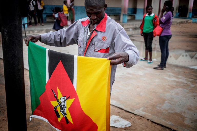 A school janitor folds the Mozambican national flag at sunset inside a Public School in Nacala, 4 July 2018, GIANLUIGI GUERCIA/AFP/Getty Images