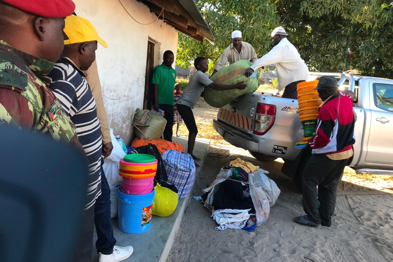 Internally displaced people offload food, blankets, and other goods after fleeing militant attacks in Naunde, northern Mozambique, 13 June 2018. A journalist was arrested after photographing families who fled the militant attacks, JOAQUIM NHAMIRRE/AFP/Getty Images