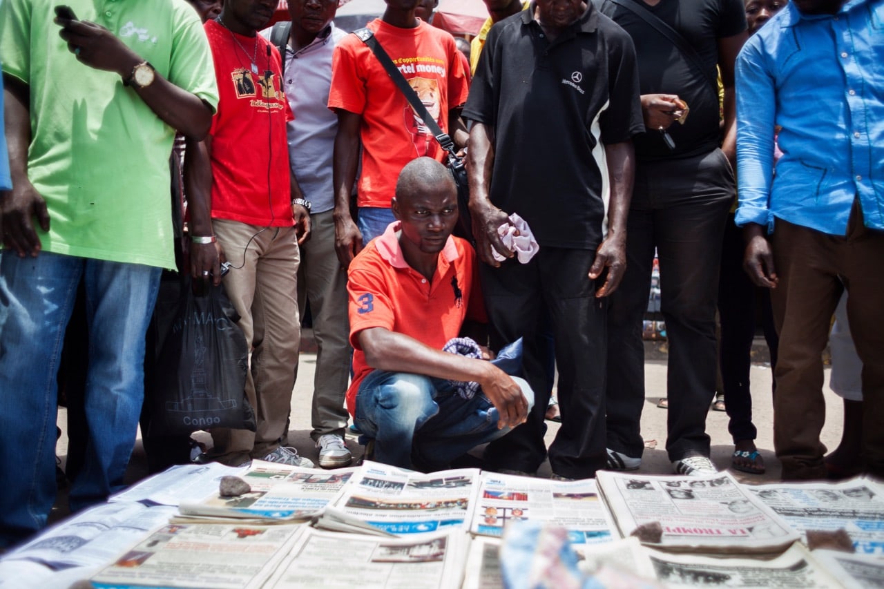 People gather around a newspaper vendor in Brazzaville, Republic of Congo, 21 March 2016, EDUARDO SOTERAS/AFP/Getty Images