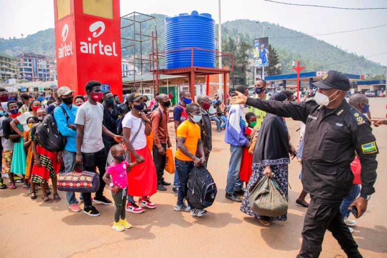 During a lockdown due to COVID-19, a police officer guides people waiting at a bus station in Kigali, Rwanda, 19 January 2021, Xinhua/Cyril Ndegeya via Getty Images