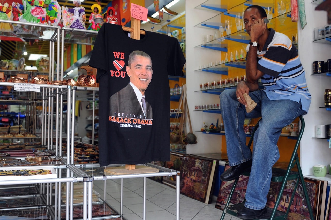 A man speaks on a mobile phone at a shop displaying a T-shirt of US President Barack Obama in Port of Spain, Trinidad and Tobago, 16 April 2009, MAURICIO DUENAS/AFP/Getty Images
