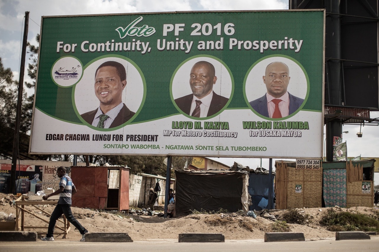 People walk by a billboard with a picture of the incumbent president Edgar Lungu, of the PF ruling Party, ahead of Presidential and legislative elections in Lusaka, Zambia, 9 August 2016, GIANLUIGI GUERCIA/AFP/Getty Images